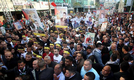 Người Palestine ở Nablus giơ cao những bức ảnh của người thân đang bị giam giữ trong các nhà tù của Israel trong một cuộc míttinh nhân Ngày Tù nhân Palestine.